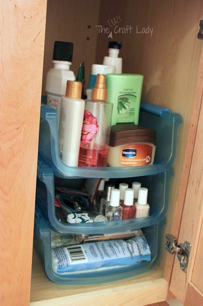 Stacking containers in a bathroom cabinet filled with products
