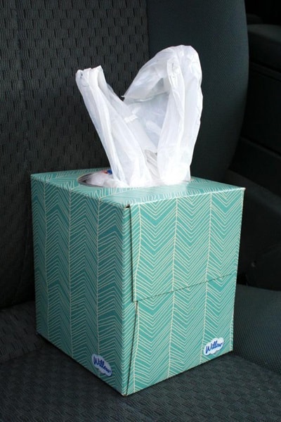 A blue tissue box filled with plastic bags